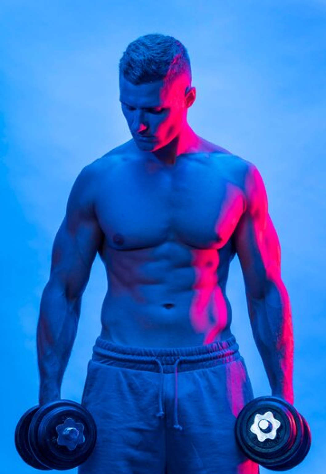 спортивный мужчина держит в руках гантели